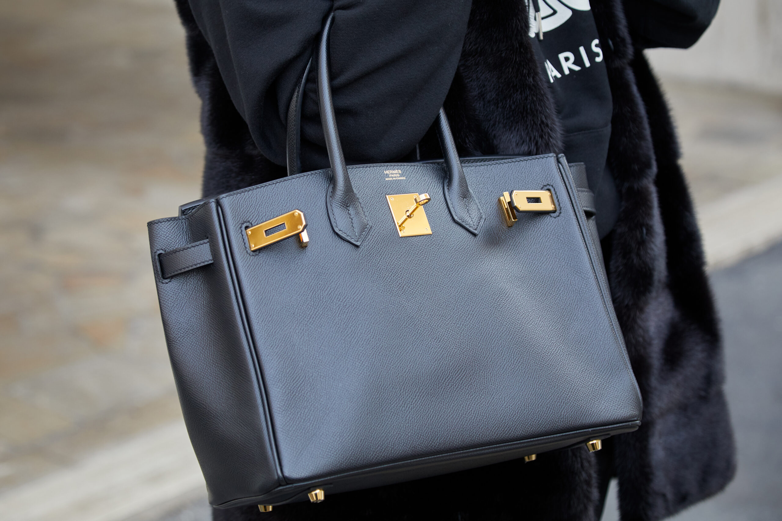 A stylish Hermès handbag, epitomizing brand desire, carried by a person on a city street.