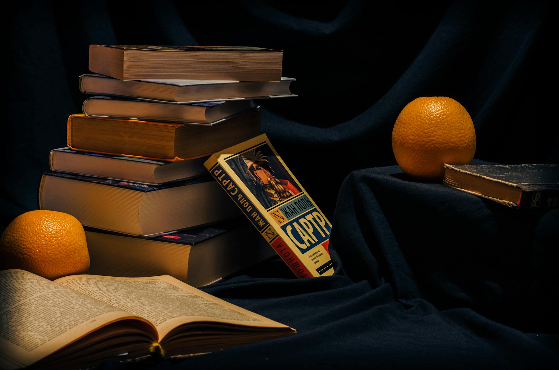 Stacked books with an orange and a prominently displayed title 'CAPTURE', symbolising authentic storytelling in a cozy, intellectual setting.