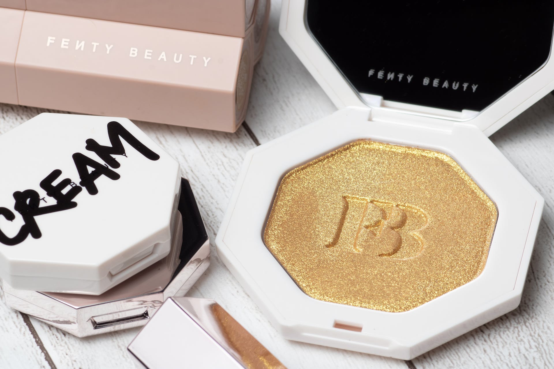 A glimpse of Rihanna's Fenty Beauty success with products on display, including a shimmering gold highlighter with the FB emblem.