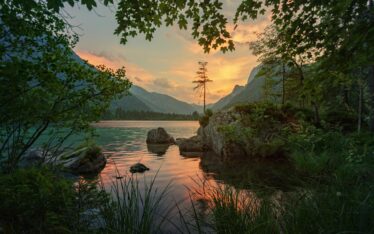 Serene lake at sunset with a backdrop of distant mountains, symbolising the journey of 'Finding Purpose Lately'. The calm waters and tranquil setting reflect deep introspection and personal growth.